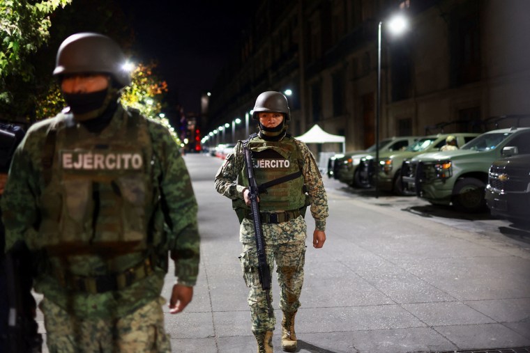 A member of the Mexican army patrols the perimeter of Palacio Nacional in Mexico