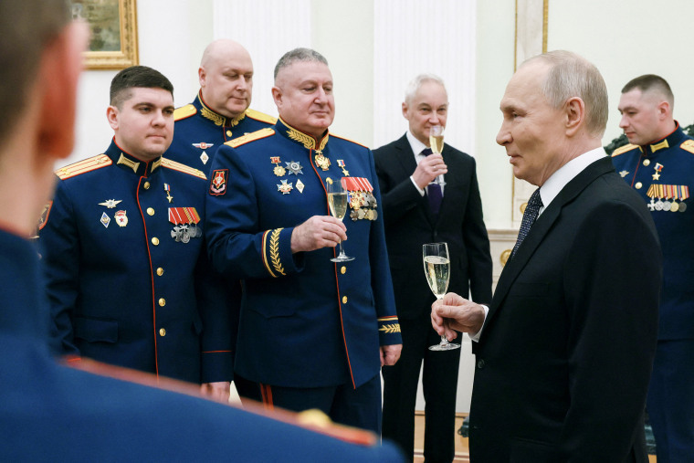 Russian President Vladimir Putin makes a toast with servicemen awarded with Gold Star medals of 'Hero of Russia' during a ceremony on Defender of the Fatherland Day in Moscow Monday.