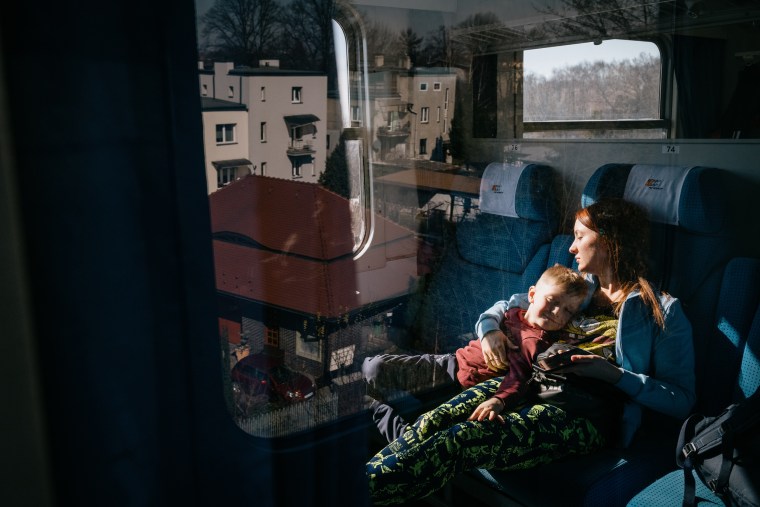 Image: Nataliia Sukhar and her 5-year-old son, Gleb, rest on a train traveling from Poland to Berlin, Germany, after fleeing the violence in Ukraine.