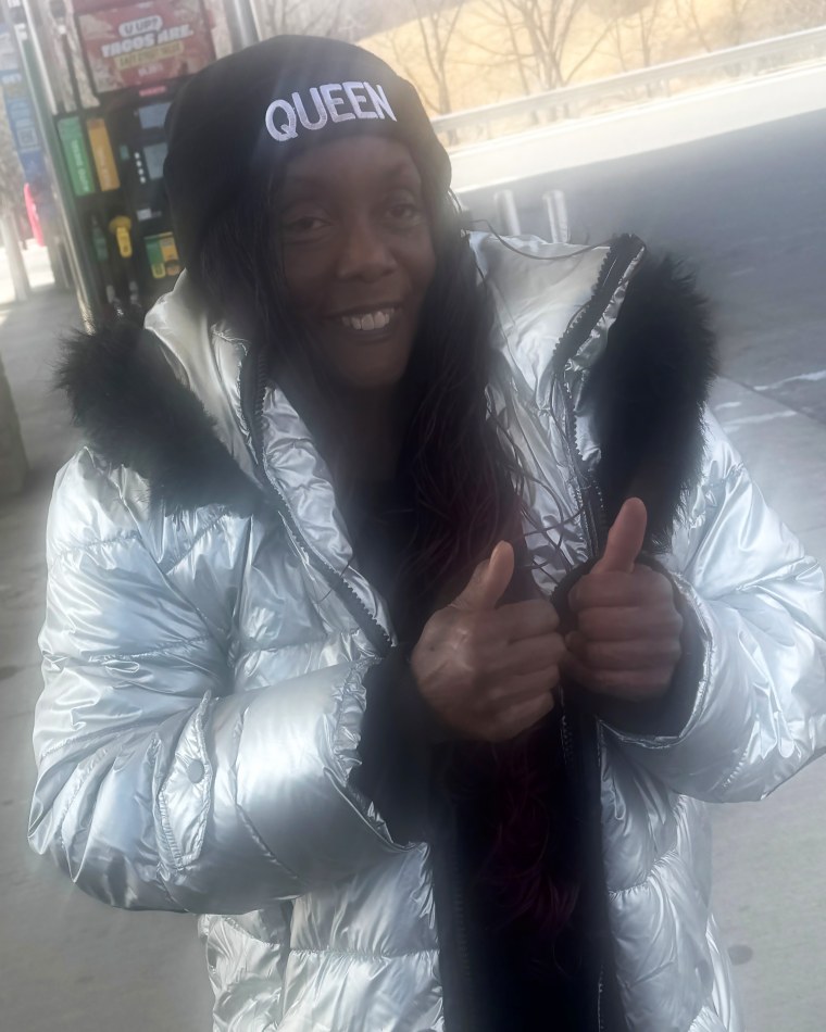 Image: A woman smiling, gesturing with two thumbs up