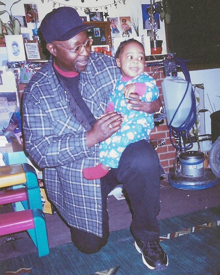 Image: A smiling father with his baby son sat on his knee