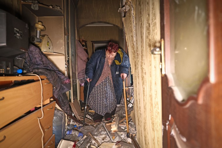 A woman hobbles on crutches inside her damaged apartment after a Russian drone hit an apartment building in Zaporizhzhia, Ukraine, Thursday, Feb. 26, 2026. 