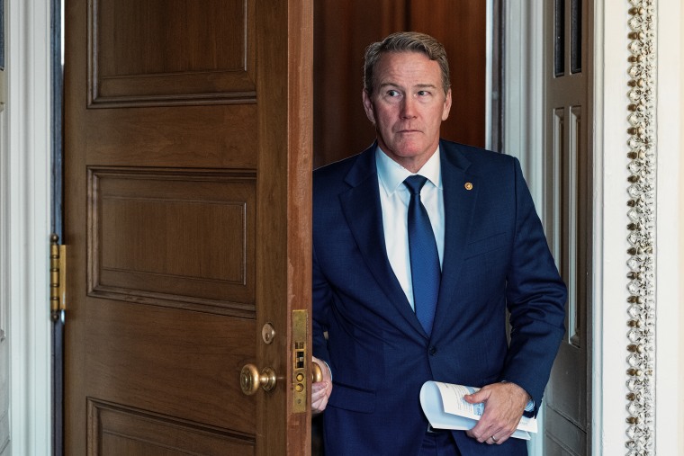 Sen. Jon Husted looks to his right, off-camera, while walking through a doorway.