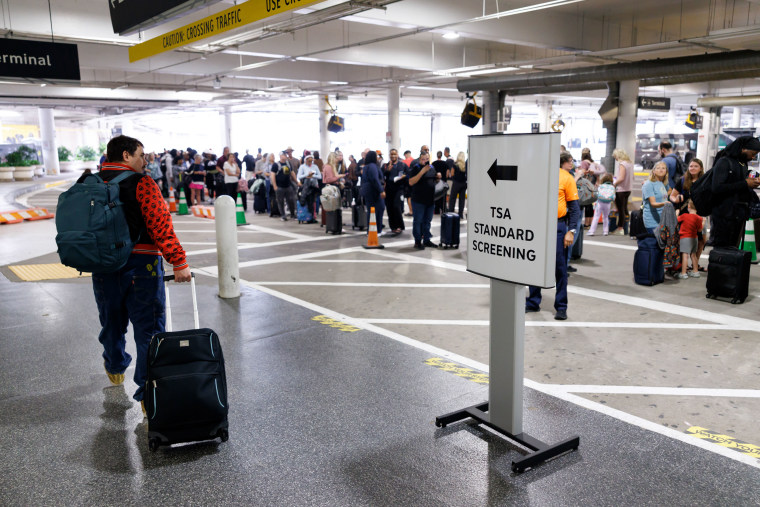 Travelers wait in line at a TSA checkpoint at William P. Hobby Airport in Houston, Texas, US, on Monday, March 9, 2026. 