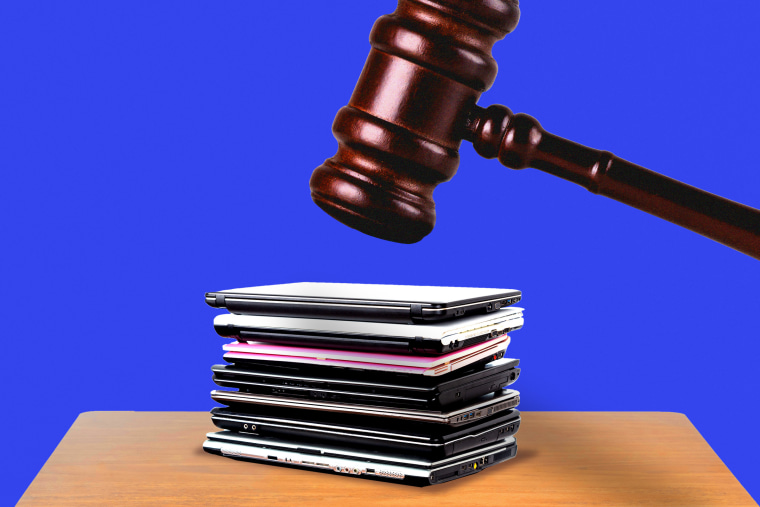 Gavel hovering above stack of laptops 