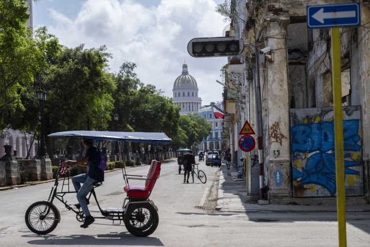 A pedicab drives past a traffic light that is out due to a power cut in Havana, Cuba.