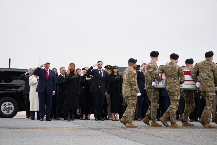Donald Trump y JD Vance saludan a los soldados mientras llevan un ataúd cubierto con una bandera estadounidense a la pista.