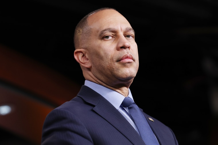 Hakeem Jeffries looks downward into the camera. 