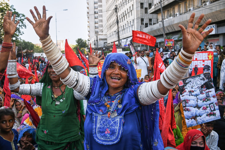 A woman raises her hands and smiles during a rally