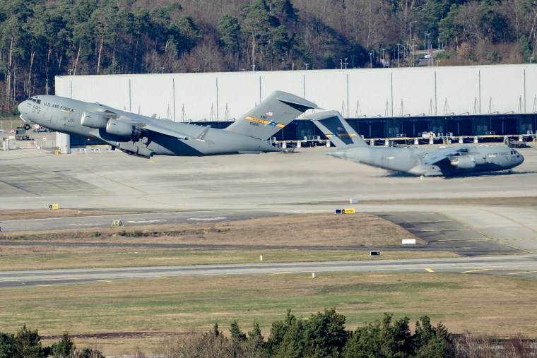 Two military jets, one on the ground and one in the air, point in opposite directions.