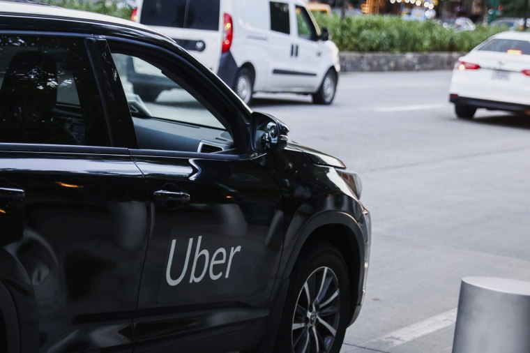 Uber logo is seen on a black car.