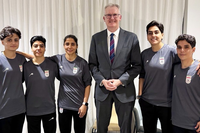 Australian Home Affairs Minister Tony Burke with five women from the team who were granted asylum Monday.