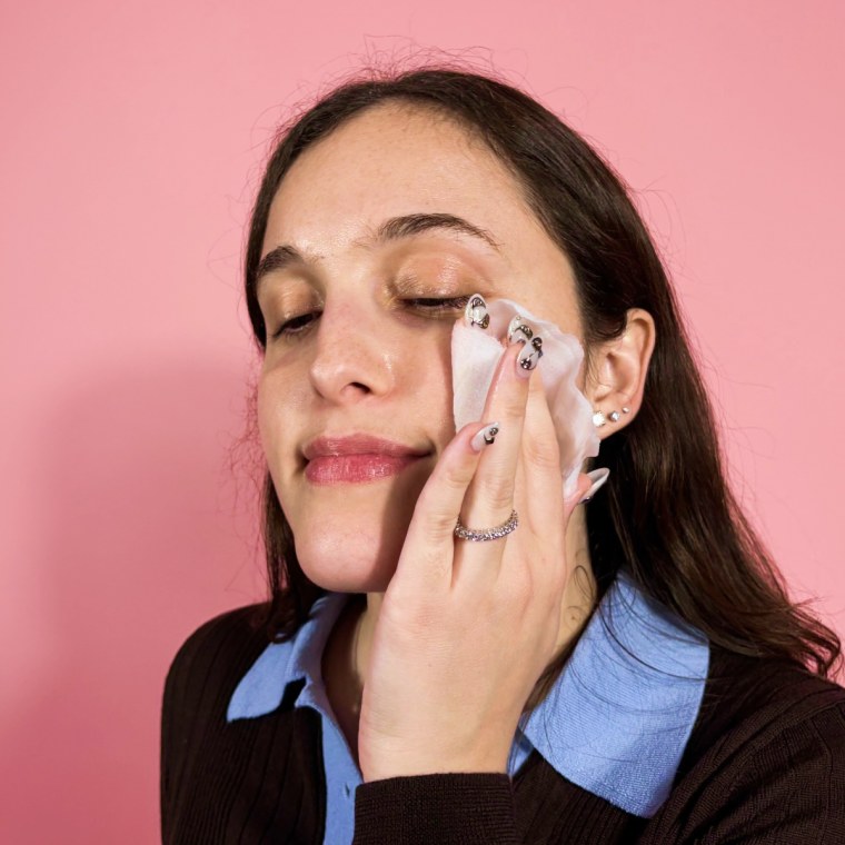 Woman applying toning pads to face