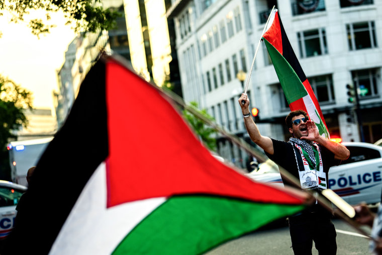 A man holds a Palestinian flag outside