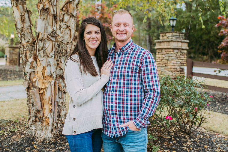 Jason Hughes, right, and his wife pose for a photo outside