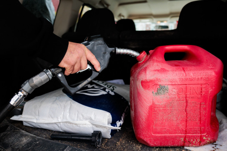 Roy Strohecker fills a red gas cannister