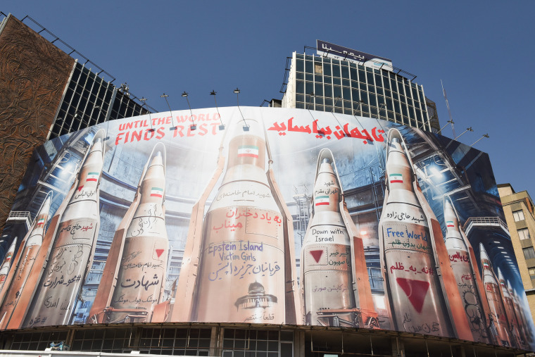 A large banner with illustrations of missiles on the side of a building in Tehran.