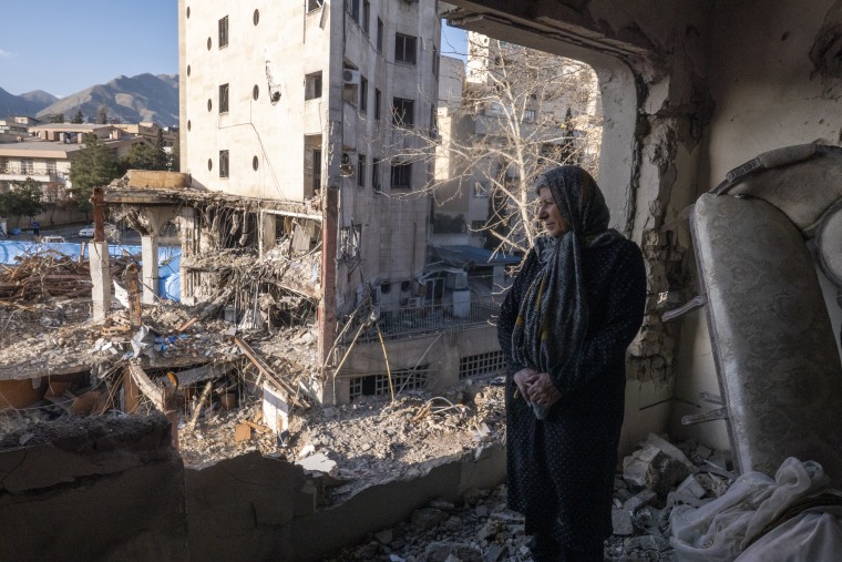 A woman looks out from her destroyed apartment in the remains of a residential and commercial building on March 21, in the Shahrak-e Gharb neighbourhood of Tehran, Iran. 