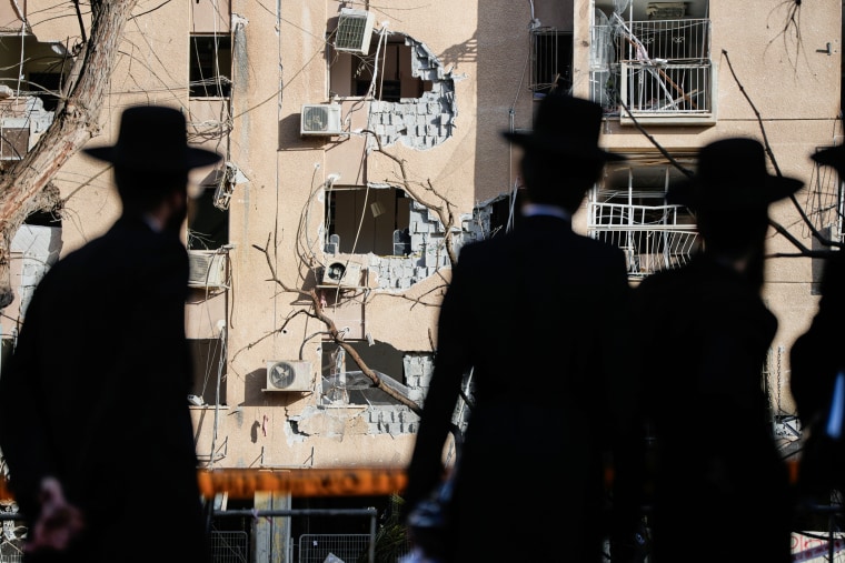 People look at residential buildings damaged