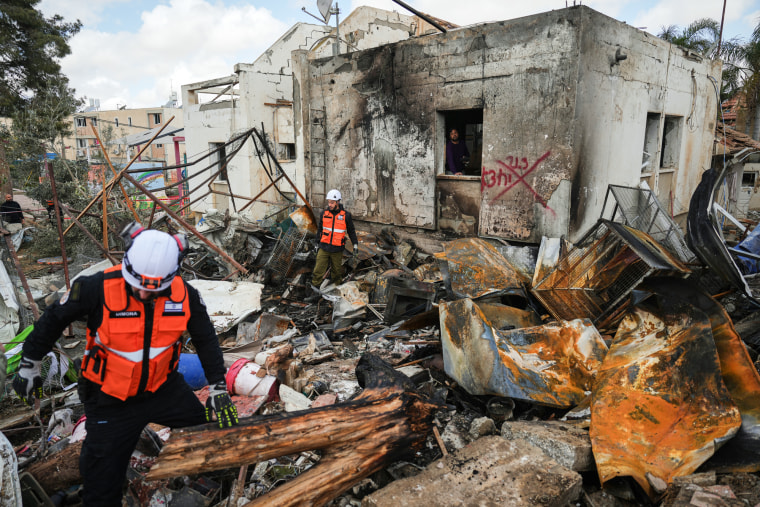 Israeli security forces survey the site that was struck by an Iranian missile