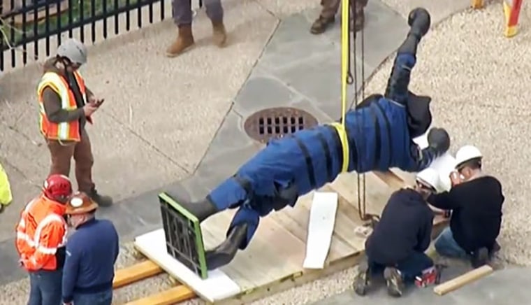 Workers prepare the Rocky statue to be moved inside the museum.