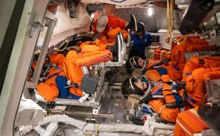 Artemis II crew members wear their spacesuits for training inside the Orion mock-up.