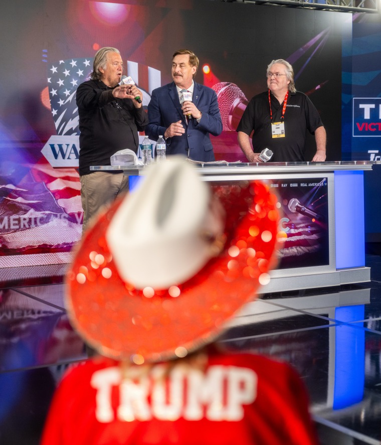 Steve Bannon, left, onstage with Mike Lindell — aka "the MyPillow guy" — and a moderator on Friday.