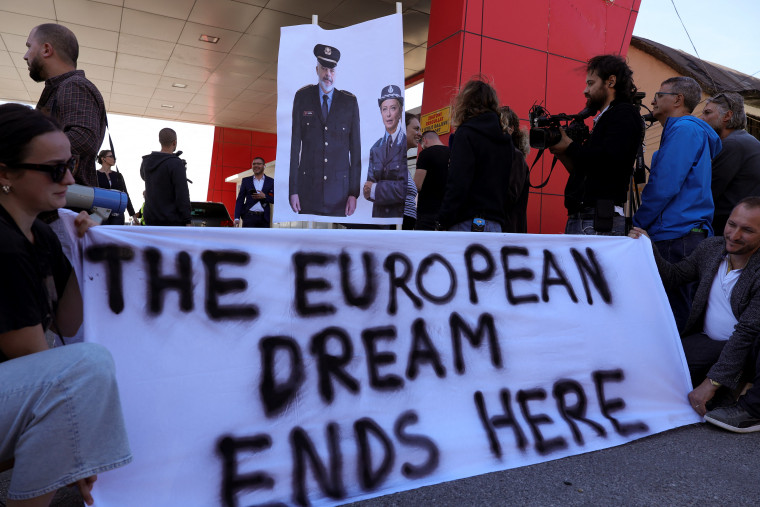 A group of civil rights activists gather in protest after a group of migrants, intercepted in Italian waters, arrives at Shengjin port in Albania on October 16, 2024. A banner reads "The European dream ends here" under a poster of Italy's Prime Minister Giorgia Meloni and Albania's Prime Minister Edi Rama.