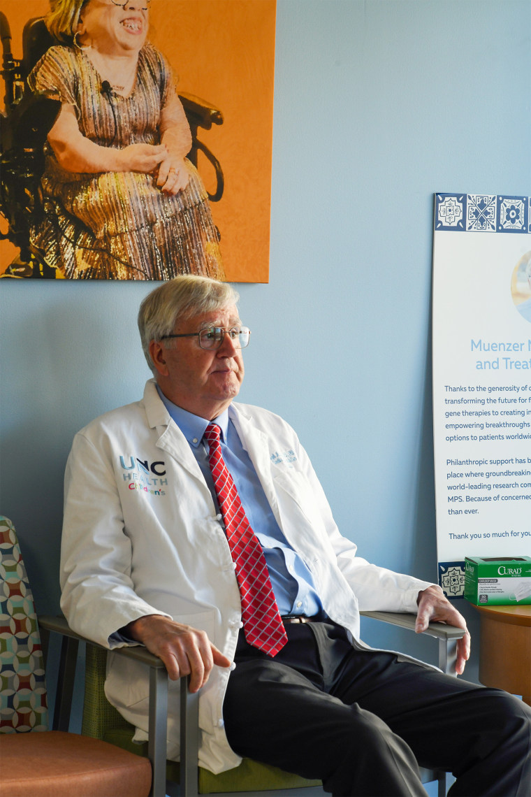 Dr. Joseph Muenzer is standing in the waiting room of the Muenzer MPS Center in Chapel Hill, NC. Photos of MPS patients are on the walls. March 29, 2026.