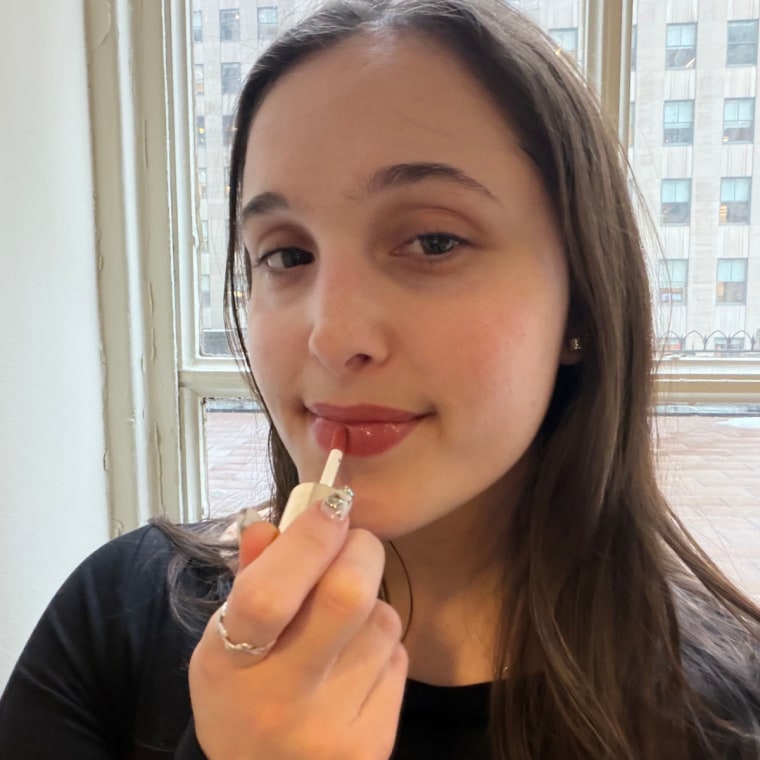 Woman applying tinted lip oil