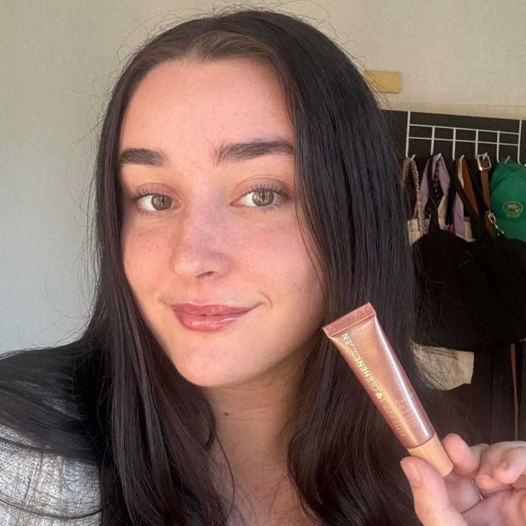 Woman showing lip treatment after applying it on lips