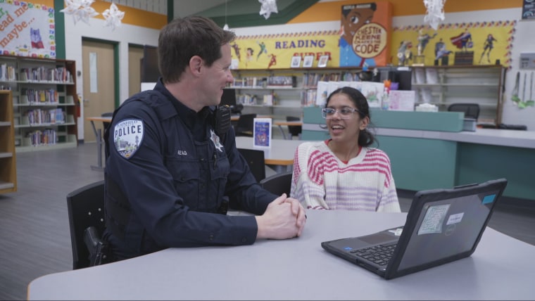 Aisha Chavda meets with a police officer to discuss the BRIGHT program. 