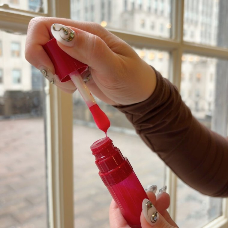 Woman holding lip oil