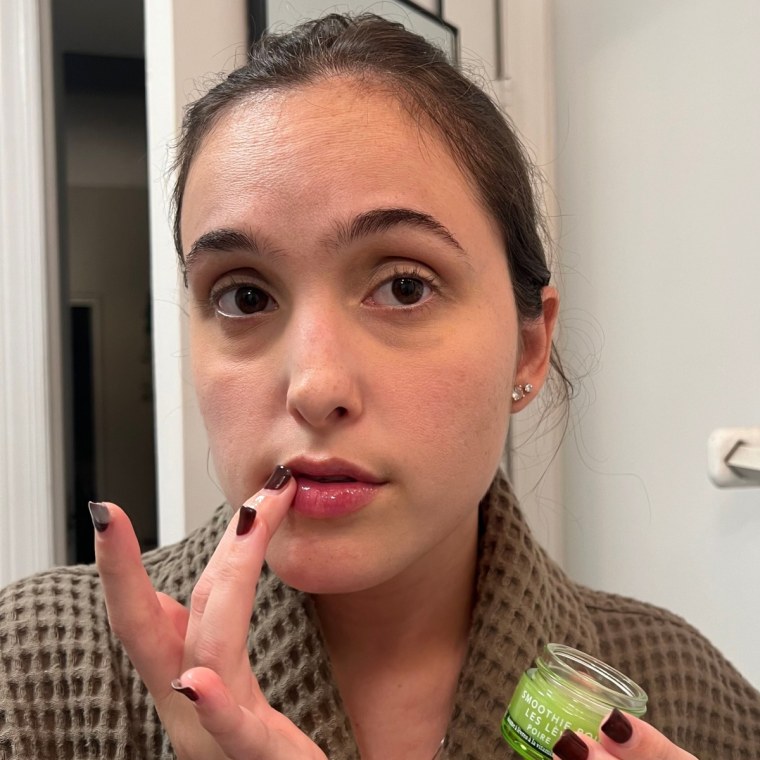 Woman applying lip serum to lips