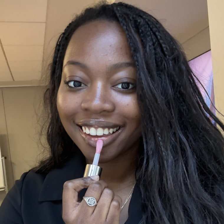 Woman applying lip oil to lips