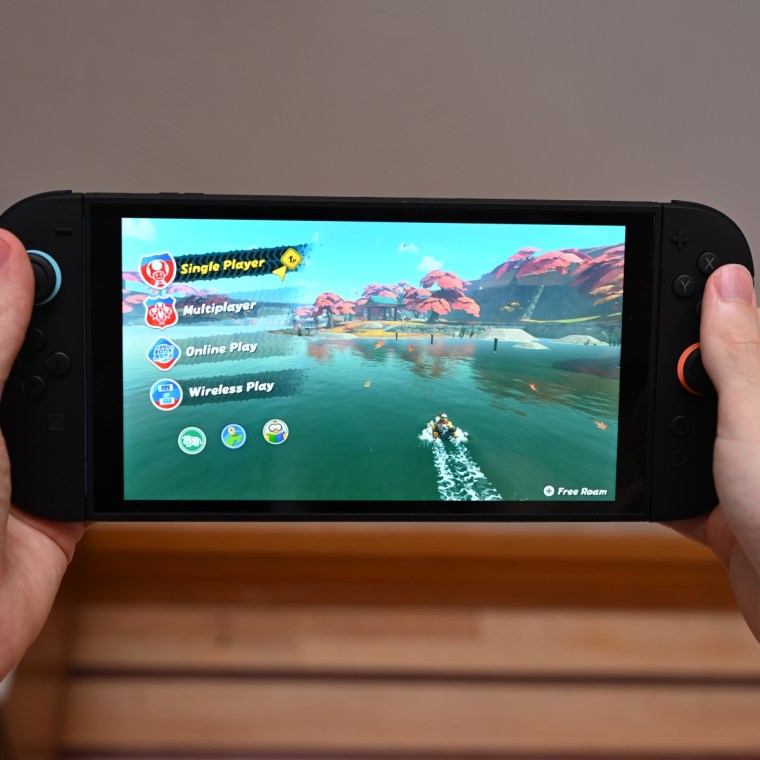 A close up of the writer holding the Switch 2 with both hands, with Mario Kart World on the screen.