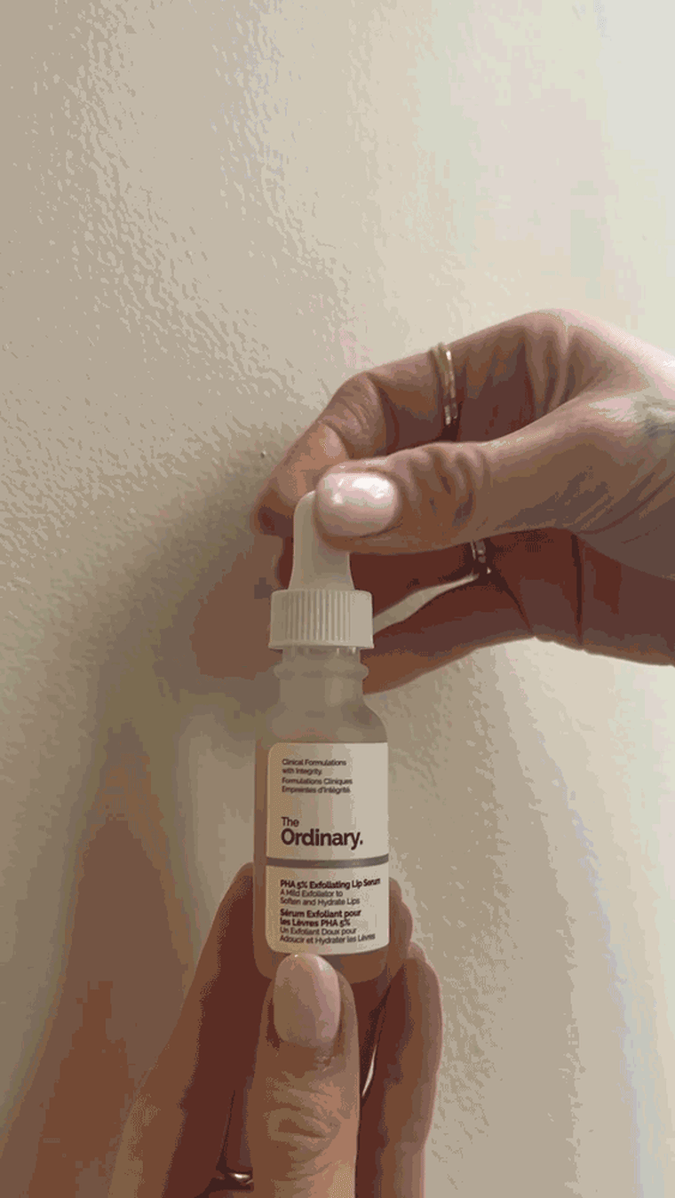 Woman squeezing serum using a dropper