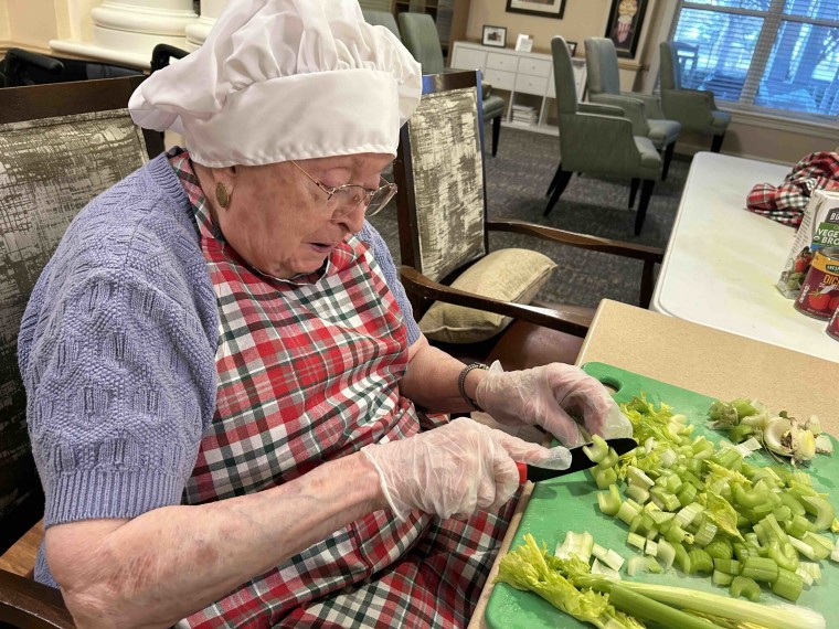 Barbara Enselaco chops celery as part of the Rolling Scones cooking club.