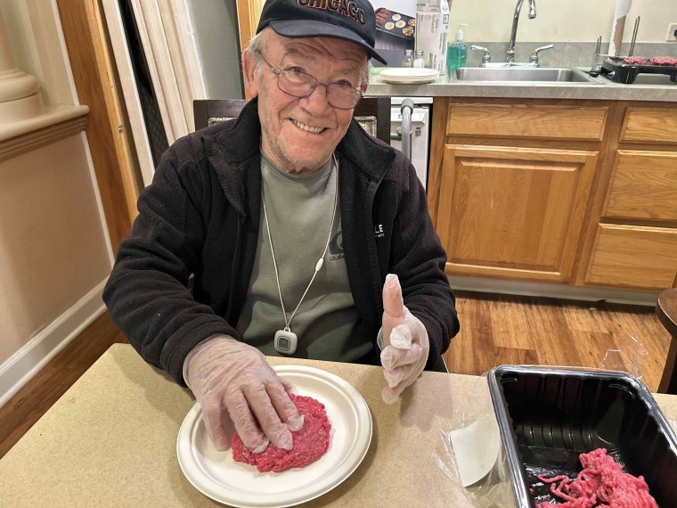 John makes hamburger patties as part of the Rolling Scones cooking club.