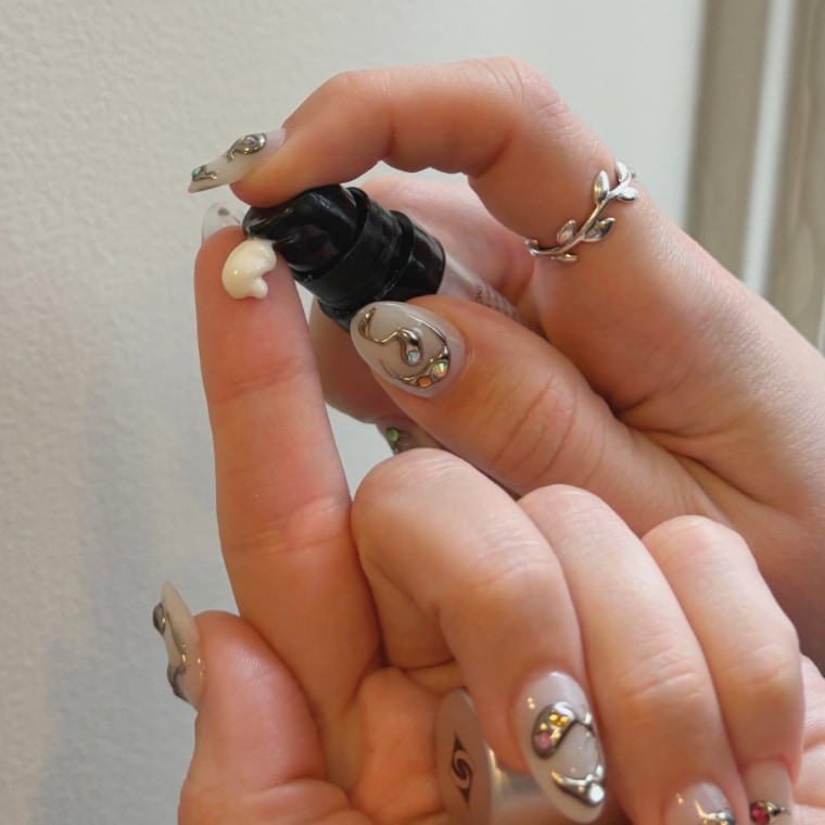 Woman pumping lip serum on finger