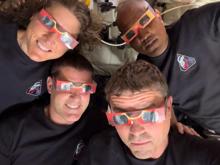 The Artemis II crew, clockwise from top left, mission specialist Christina Koch, pilot Victor Glover, commander Reid Wiseman and mission specialist Jeremy Hansen uses eclipse viewers during the solar eclipse they experienced during their lunar flyby.