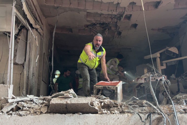 Rescuers search for victims inside a destroyed apartment at the site of an Israeli airstrike in central Beirut