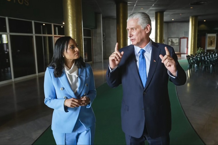 Kristen Welker and Miguel Díaz-Canel speak to each other while walking inside of a building