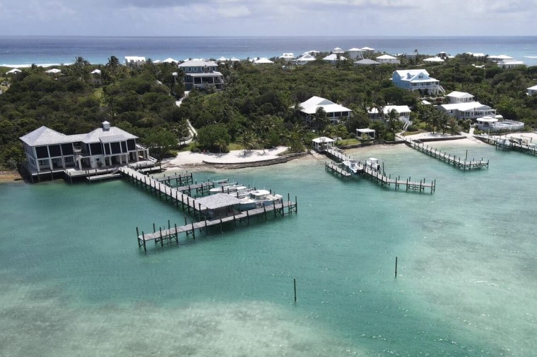 An aerial view of a Caribbean island with piers over the water. 