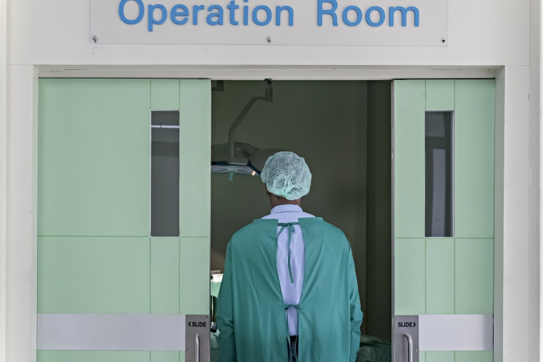 A surgeon doctor is entering to an emergency operation room.