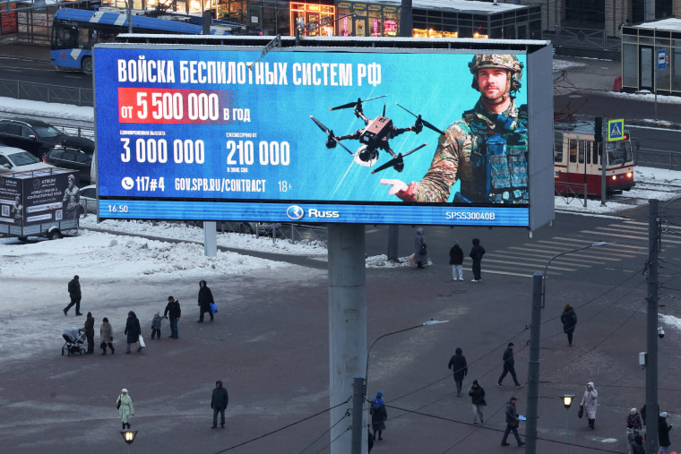  People walk under an ad promoting contract military service in Russian army, in St Petersburg
