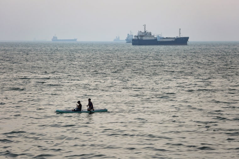 ships are anchored near the shoreline along the Strait of Hormuz