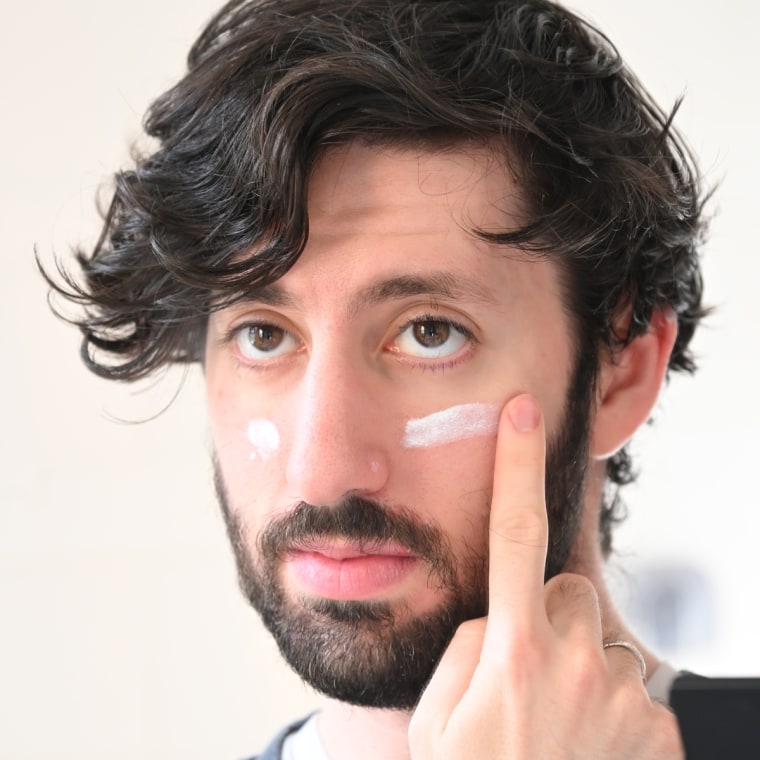 Man putting sunscreen on face