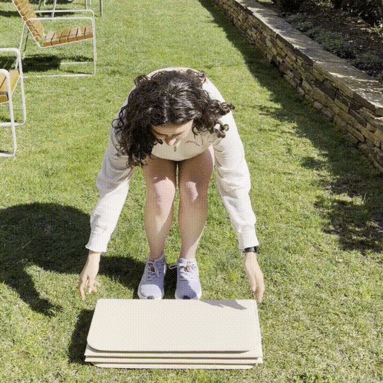 Woman unfolding Stakt Mat Pro