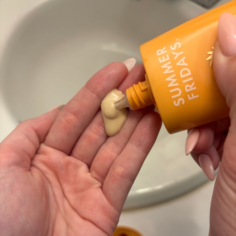 Woman squeezing sunscreen on hand